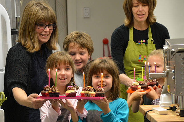 enfants qui apportent des cupcakes d'anniversaire au fêté
